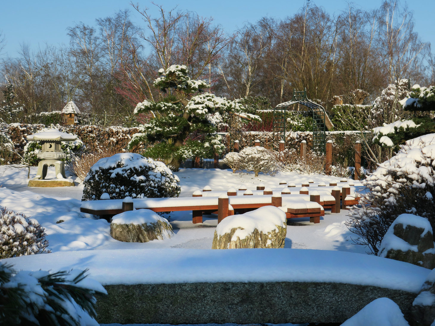 a Japanese Yukimi snow lantern covered in snow in the garden